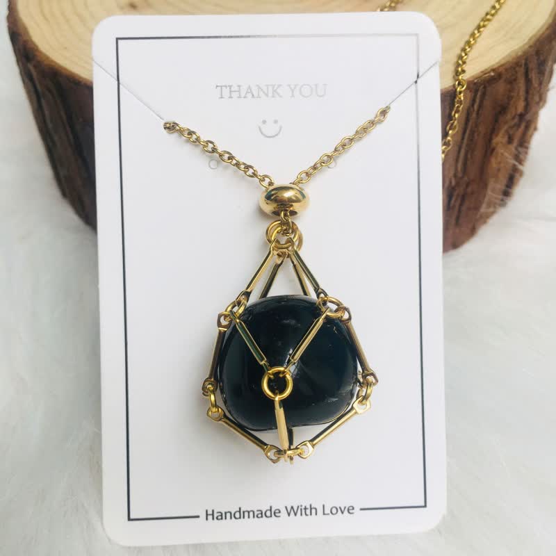 Goldene Halskette mit schwarzem Anhänger, handgefertigt, elegantes Schmuckdesign, Geschenkidee.