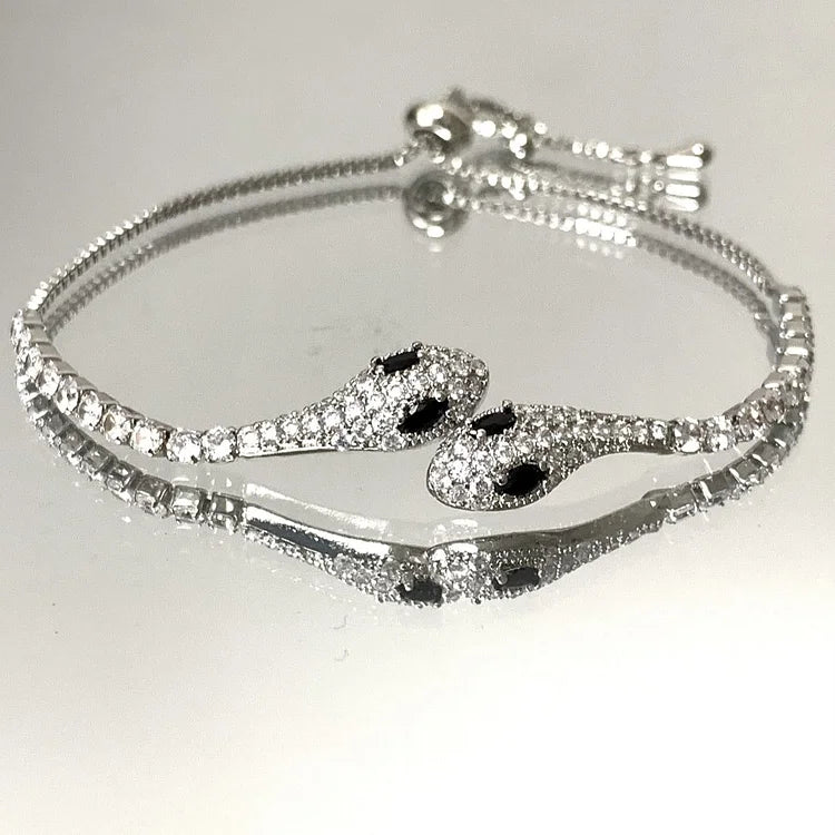 Silbernes Schlangenarmband mit Strasssteinen, verstellbar, elegantes Schmuckdesign.