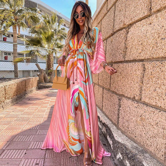 Frau in rosa abstraktem Print-Maxikleid mit Gürtel, V-Ausschnitt, Sommermode, draußen.