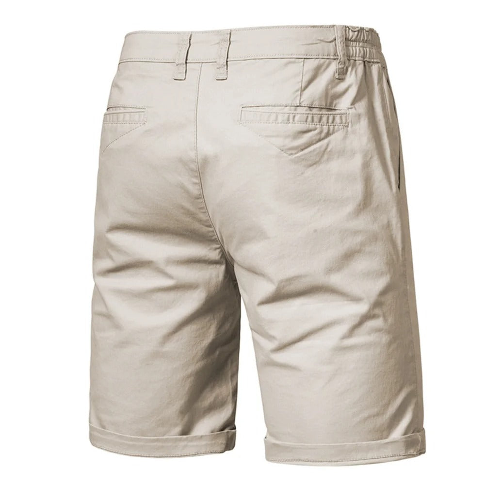 Baksidan av beige shorts med två påsydda bakfickor, skärmlinningar och uppvikta benslut. 2