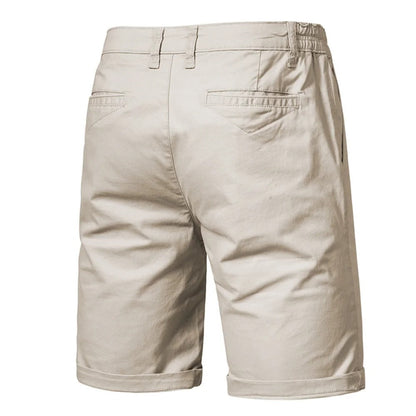 Baksidan av beige shorts med två påsydda bakfickor, skärmlinningar och uppvikta benslut. 2