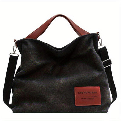 Schwarze Canvas-Schultertasche mit braunen Griffen, lässig, modisch, vielseitig.