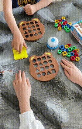 Kinder spielen mit Bär-Form-Puzzle, bunte Ringe, Tischspielzeug, Lernspiel, Hand-Aktivität.
