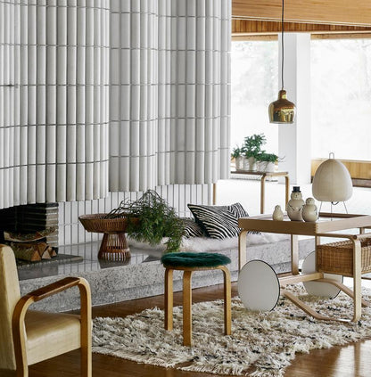 Moderne Wohnzimmerdekoration mit Akari Tischlampe, Holzstuhl, Teppich und Pflanzen.