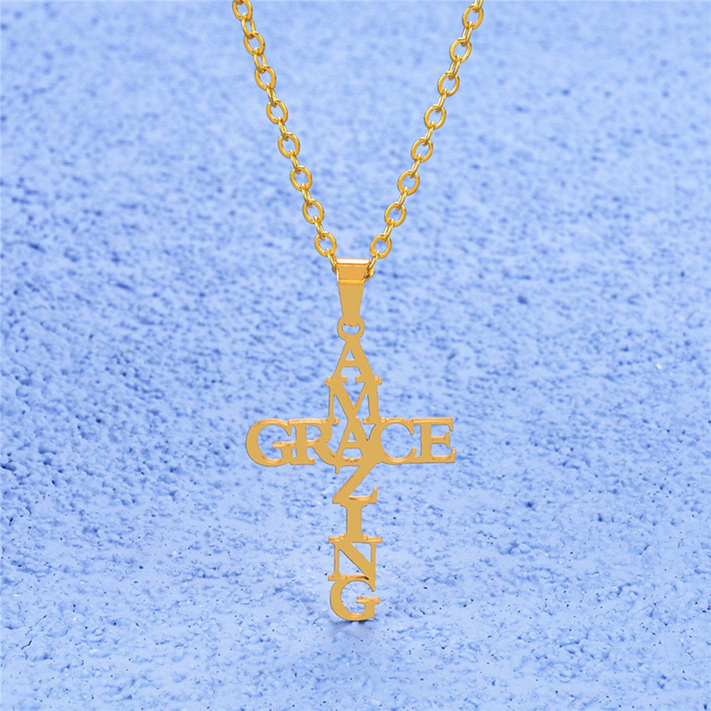 Goldene Kreuzkette "Amazing Grace" auf blauem Hintergrund, modischer Schmuckanhänger.