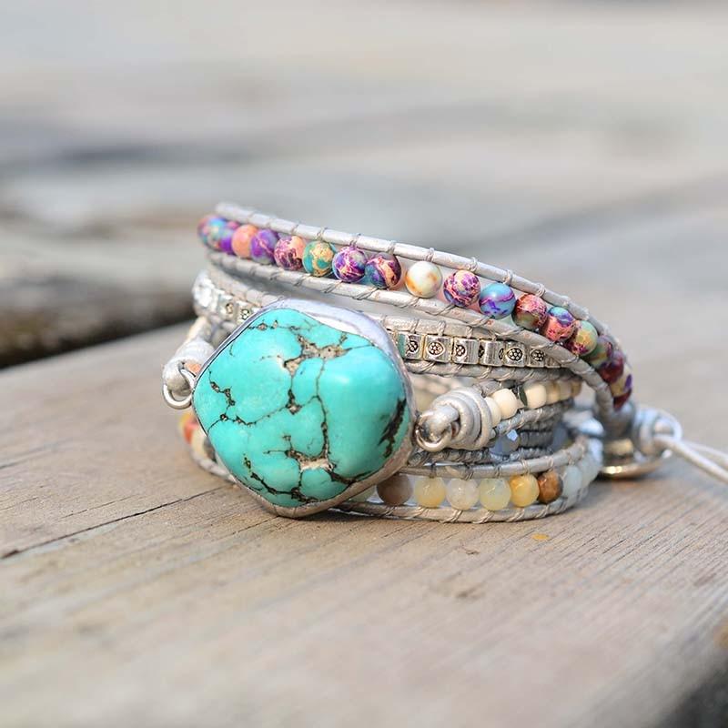 Mehrlagiges Armband mit türkisfarbenem Amazonit-Stein und bunten Perlen auf Holztisch.