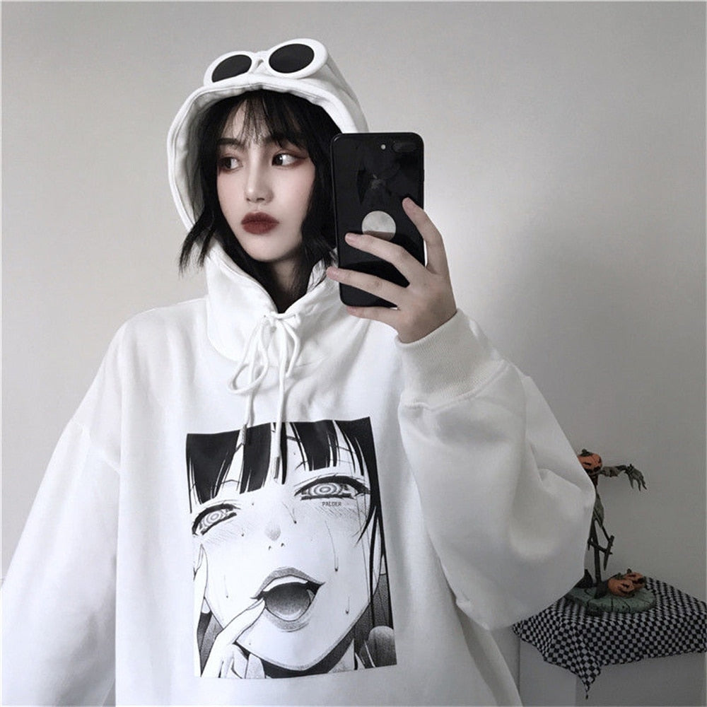 Frau im weißen Anime-Hoodie mit Kapuze und Smartphone, modisch, lässig, Streetwear.