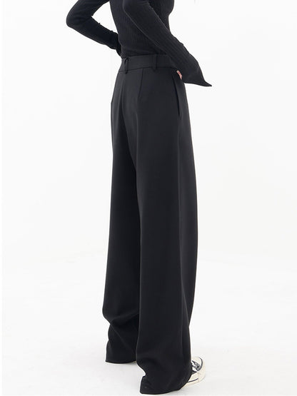 Frau trägt schwarze, asymmetrische Baggy-Hose, modisch, elegant, Damenmode, Streetwear.
