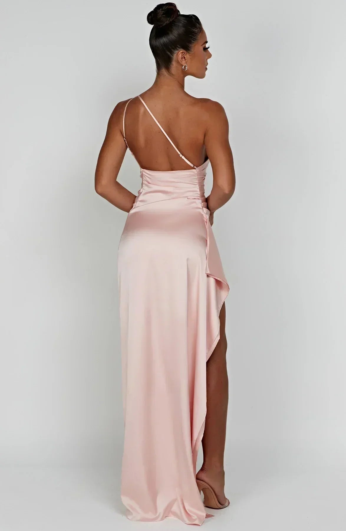 Frau in rosa Maxikleid mit asymmetrischem Träger, elegantes Abendkleid, Rückansicht.