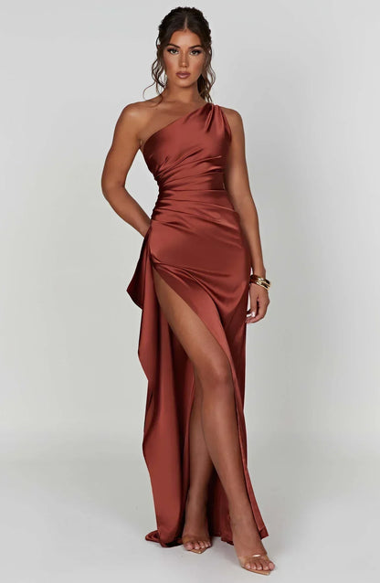 Frau in rostfarbenem Satin-Maxikleid mit Beinschlitz, elegantes Abendmode-Outfit.