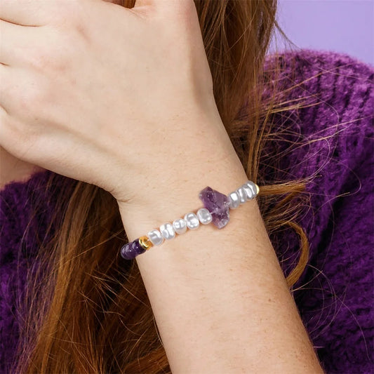 Frau mit Armband aus Amethyst und Perlen, lila Pullover, Nahaufnahme, Schmuckmode.