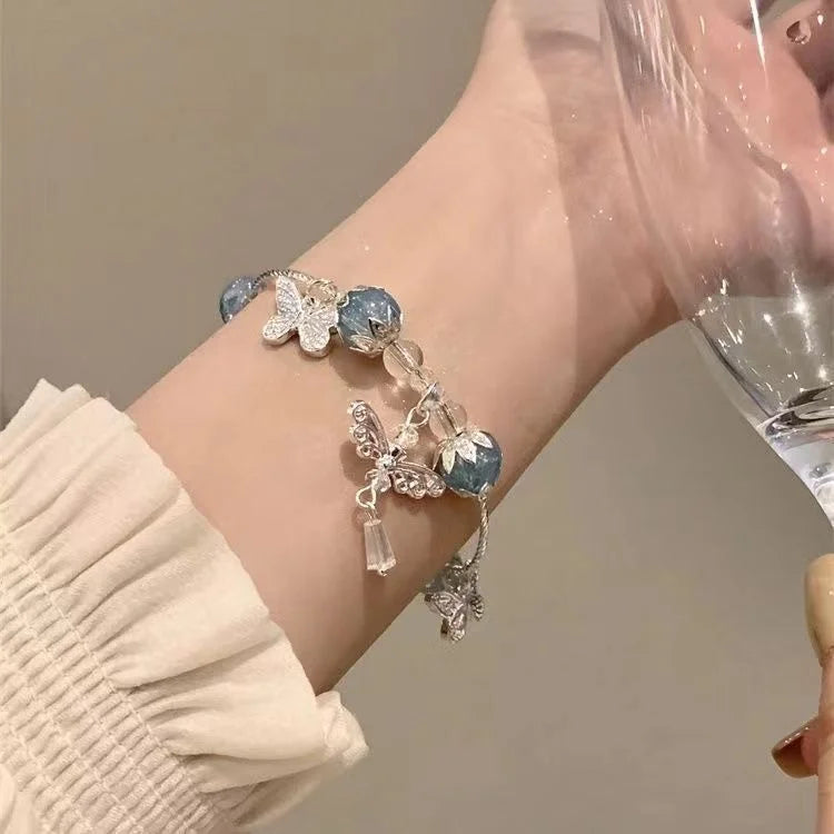 Silberarmband mit blauen Perlen und Schmetterlingsanhängern, eleganter Schmuck für Damen.