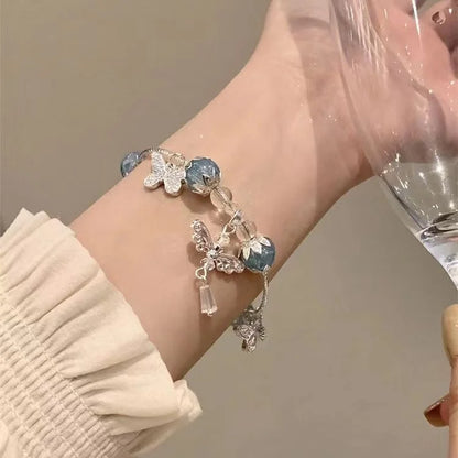 Silberarmband mit blauen Perlen und Schmetterlingsanhängern, eleganter Schmuck für Damen.