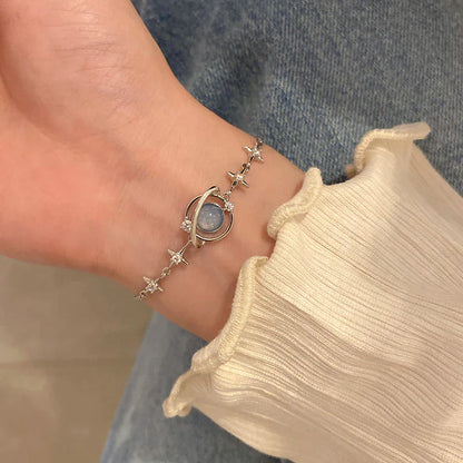 Damenarmband mit blauem Stein und Sternen, silberfarben, elegantes Design, modisches Accessoire.