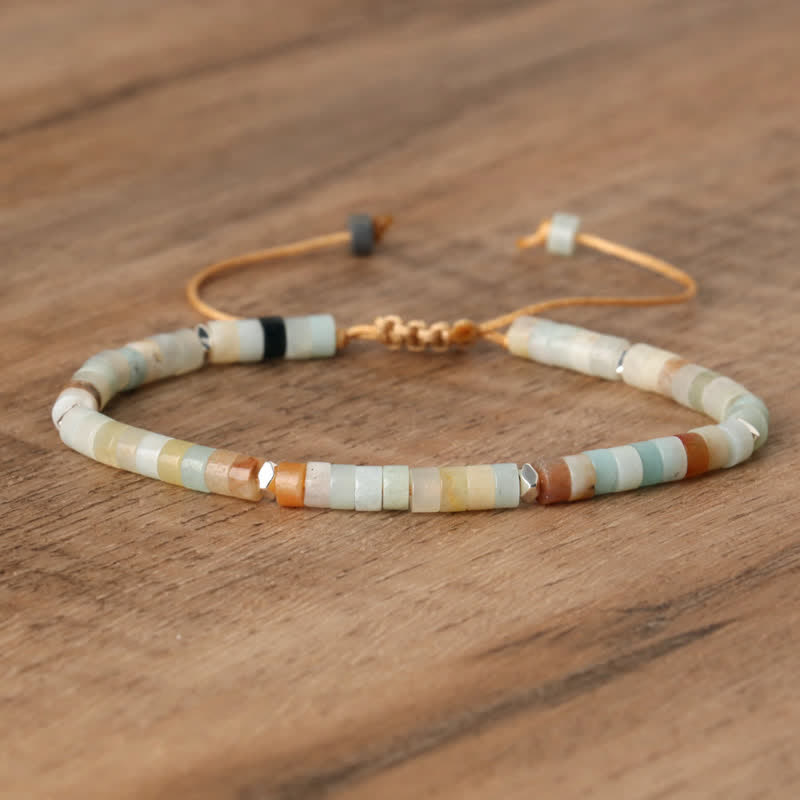 Armband aus bunten Edelsteinperlen auf Holzoberfläche, verstellbar, handgefertigt.