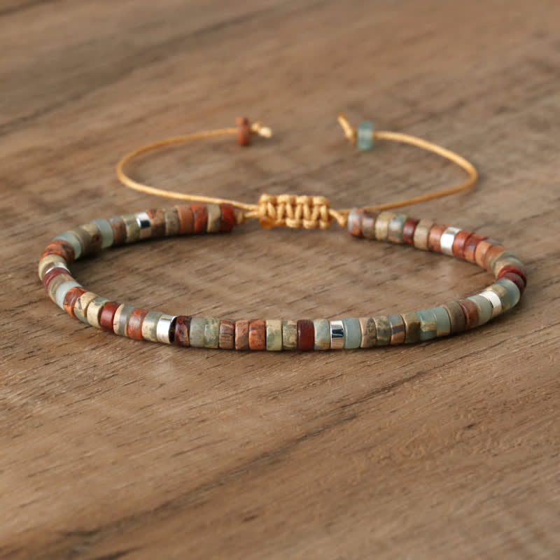 Armband aus Natursteinperlen, verstellbar, handgefertigt, mehrfarbig, auf Holztisch.