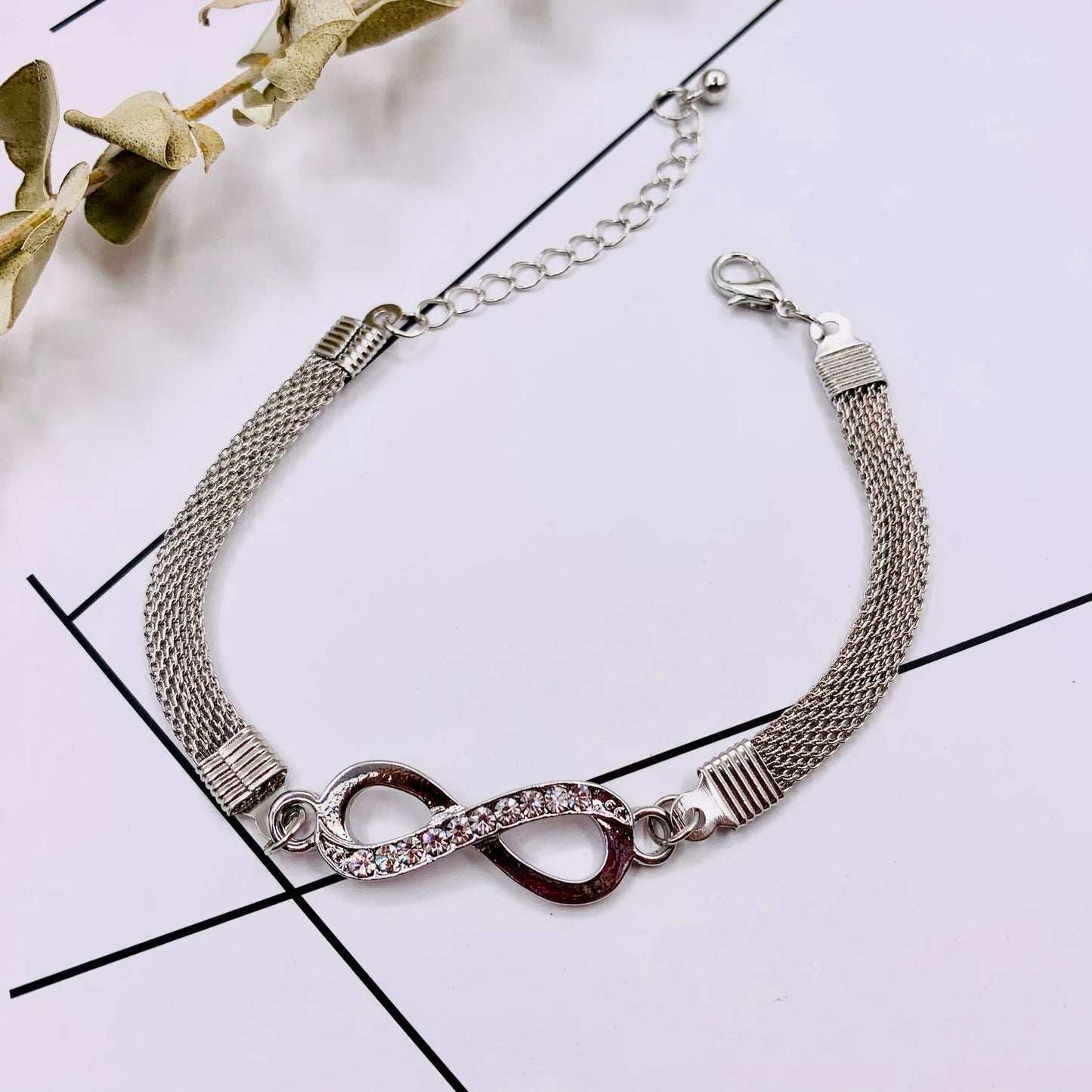 Silbernes Unendlichkeit-Armband mit Strasssteinen, verstellbar, elegantes Schmuckdesign.