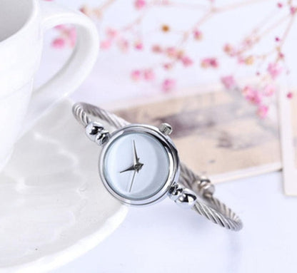 Silberne Damenarmbanduhr mit rundem Zifferblatt, elegantes Design, auf weißem Hintergrund.
