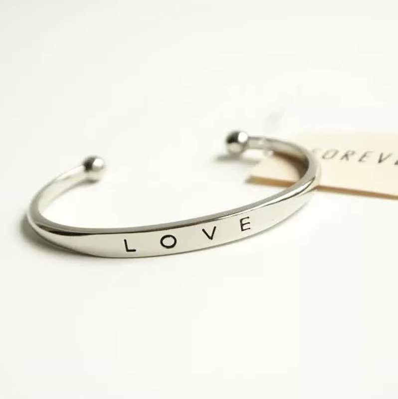 Silberarmreif mit Gravur "LOVE", minimalistisches Design, elegantes Schmuckstück für Damen.