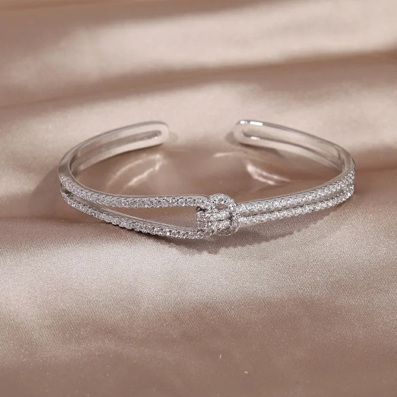 Silbernes Armreif mit Strasssteinen, elegantes Schmuckdesign, glänzend, modisch, Damenaccessoire.