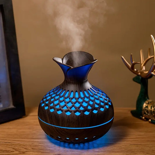 Dunkelbrauner Aromadiffusor mit blauer LED-Beleuchtung, Holzoptik, auf Holztisch.