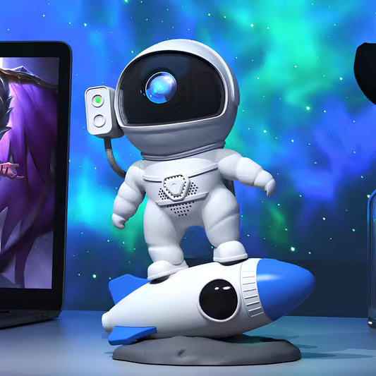 Astronautenfigur auf Rakete, blau-weiß, vor Laptop, Weltraum-Dekoration, Kinderzimmer-Deko.