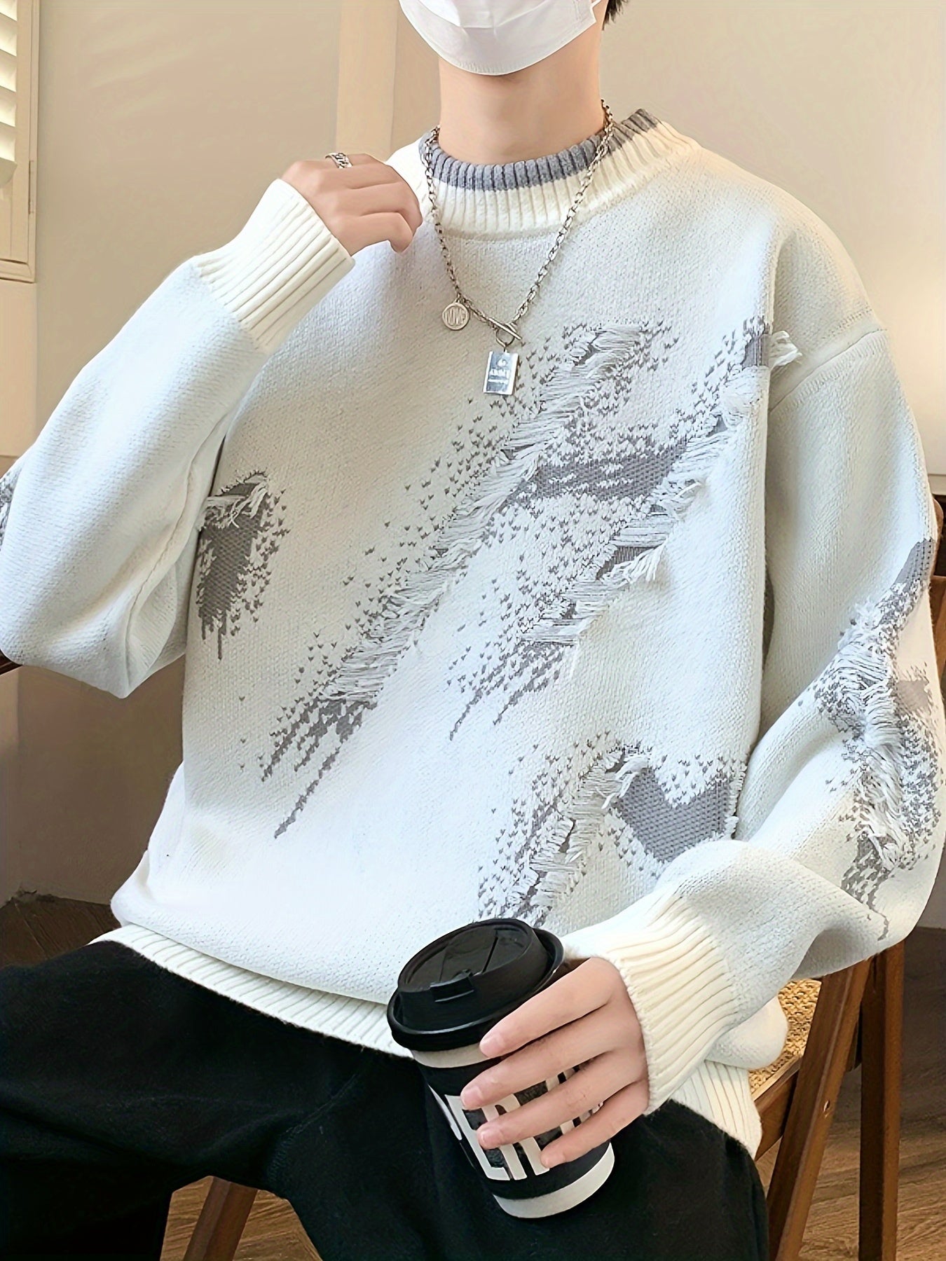 Mann in weißem Strickpullover mit Muster, hält schwarzen Kaffeebecher, modisch, lässig.