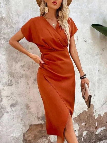 Frau in orangefarbenem Sommerkleid, Strohhut, beige Tasche, modisch, elegant, lässig.