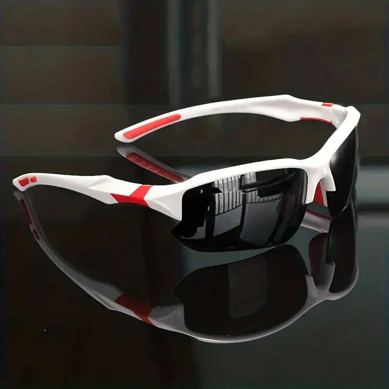 Weiße Sportsonnenbrille mit roten Akzenten und schwarzen Gläsern auf reflektierender Oberfläche.
