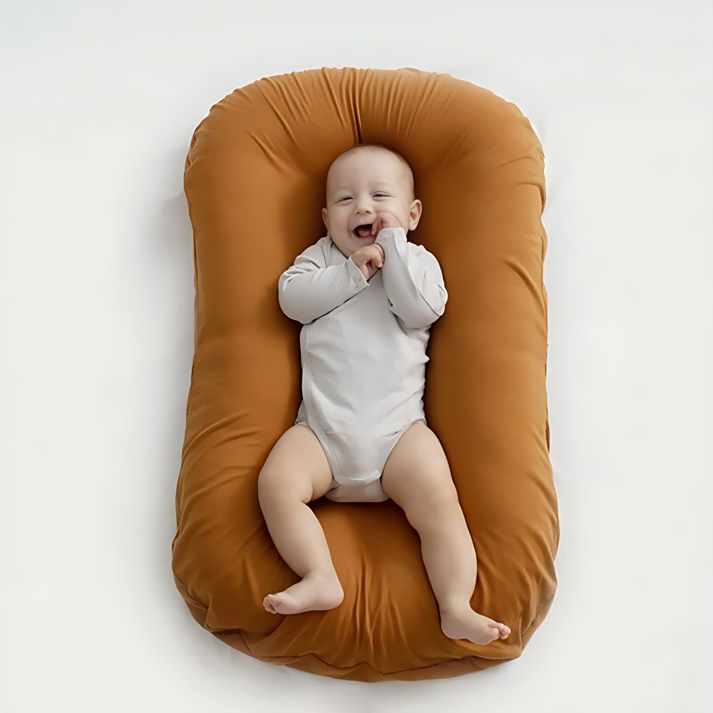 Lachendes Baby auf braunem Babynest, gemütlich, weich, sicher, ideal für Neugeborene.