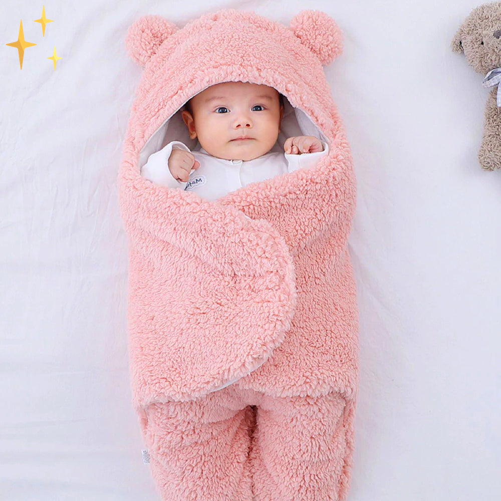 Baby in rosa Plüsch-Babyschlafsack mit Kapuze und Ohren, weich und warm, ideal für Neugeborene.