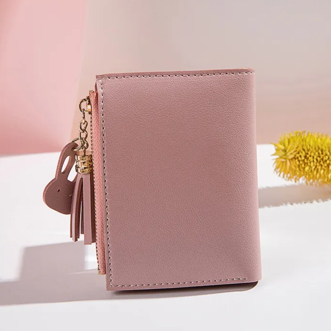 Rosa Damen-Geldbörse aus Leder mit Reißverschluss und Anhänger, stilvoll und kompakt.
