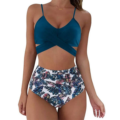 Frau in blauem Bikini-Top und tropisch gemusterter High-Waist-Badehose.