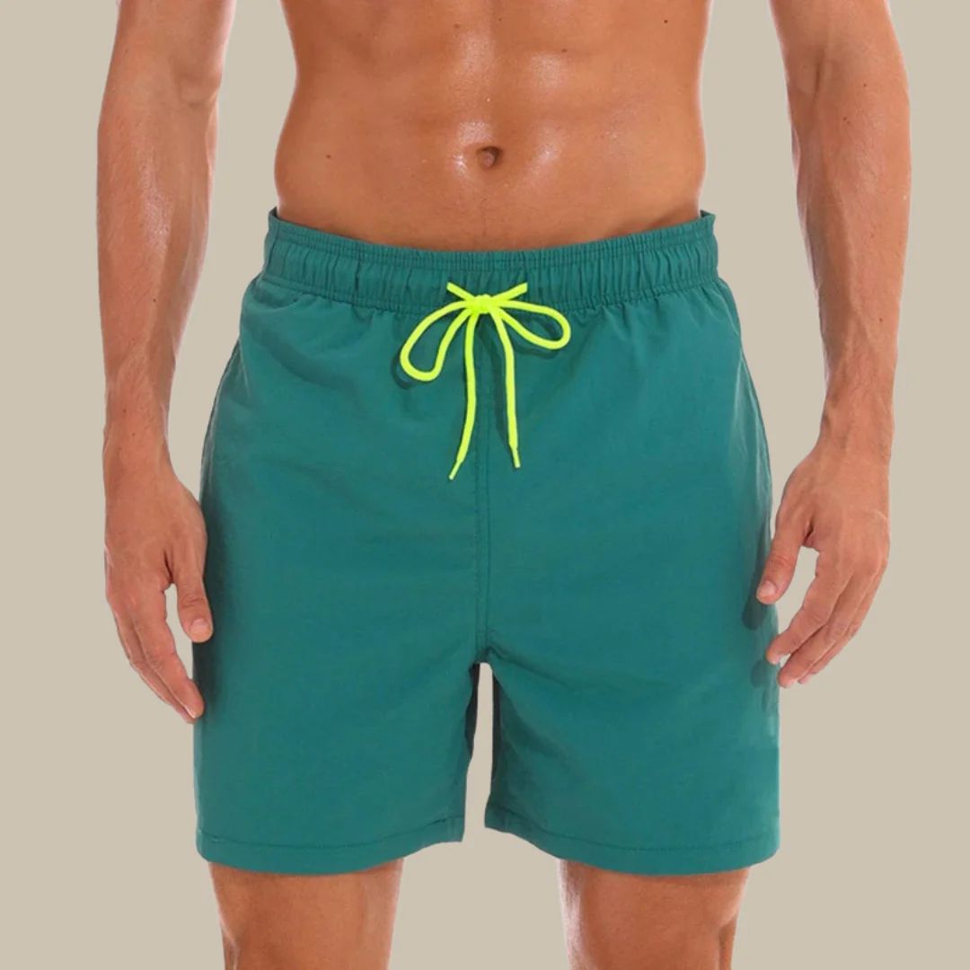 Mann in grüner Badehose mit gelbem Kordelzug, Strandmode, Sommerbekleidung Herren.
