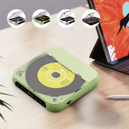 Grön CD-spelare med gul skiva på ett skrivbord bredvid en surfplatta, med fyra små bilder på de olika färgerna ovanför. 6