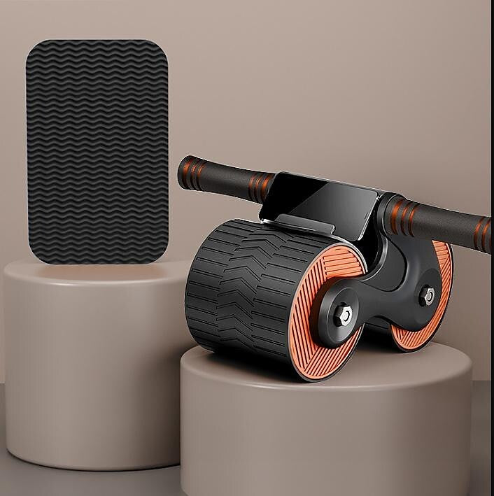 Schwarzes Fitness-Ab Roller mit Griffen und Smartphone-Halter auf beigem Podest.