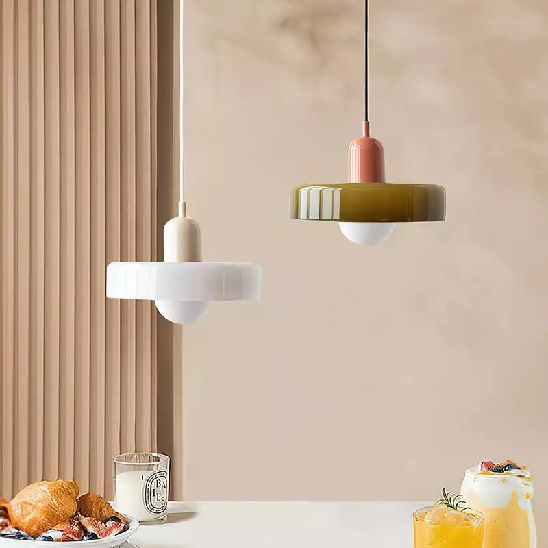Zwei Bauhaus-Hängelampen, weiß und olivgrün, modernes Design, über Tisch mit Frühstück.