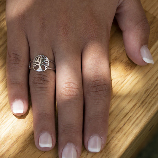 Silberring mit Lebensbaum-Motiv auf Hand, Holzoberfläche, Schmuck, Damenring, Geschenkidee.