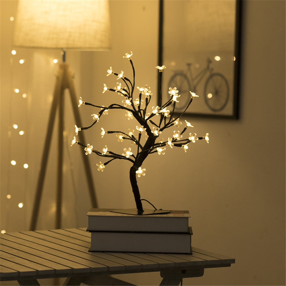 LED-Baumlampe mit warmweißen Lichtern auf Tisch, dekorative Beleuchtung, Innenraum.