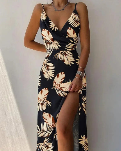 Schwarzes Maxikleid mit tropischem Blattmuster, ärmellos, tiefer Ausschnitt, hoher Schlitz.