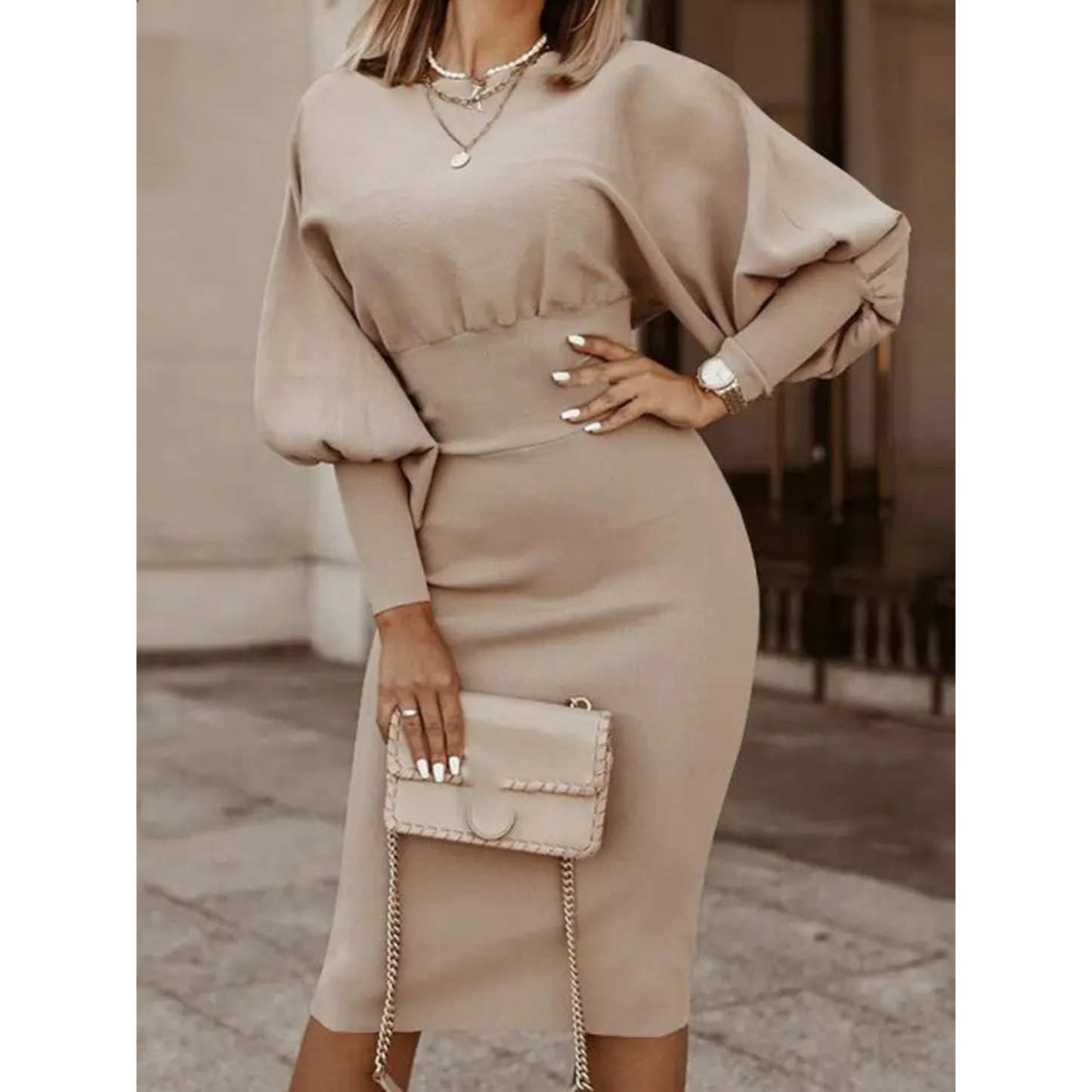 Frau in beige Cocktailkleid mit Laternenärmeln, hält eine beige Handtasche, elegantes Outfit.