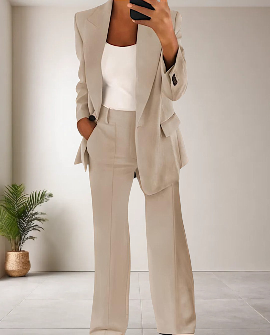 Frau im beigen Anzug mit weißem Top, moderne Büro-Outfit, elegantes Design, Innenraum.