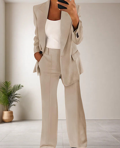 Frau im beigen Anzug mit weißem Top, moderne Büro-Outfit, elegantes Design, Innenraum.