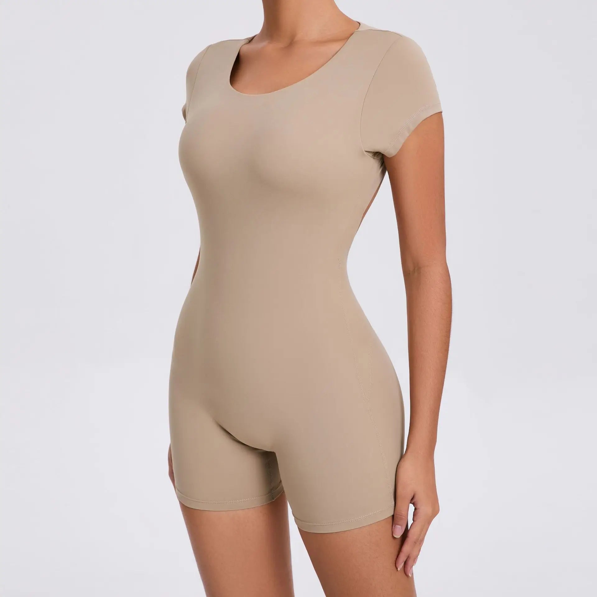 Frau in beigefarbenem Kurzarm-Body, nahtlos, figurbetont, ideal für Fitness und Freizeit.