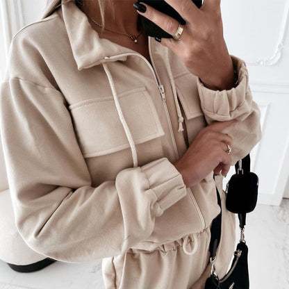Beige Damen-Trainingsanzug mit Reißverschluss, Kapuze und Taschen, modisch und bequem.