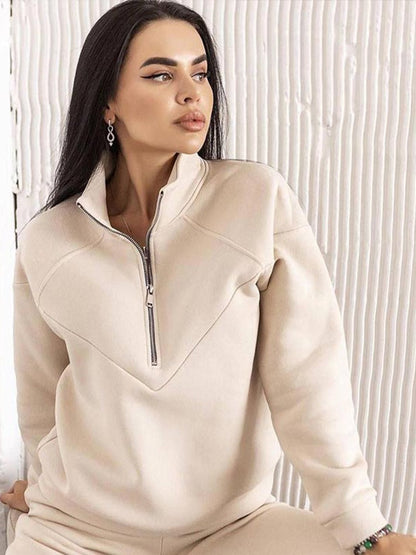 Frau in cremefarbenem Fleece-Pullover mit Reißverschluss, modisch, bequem, Herbstmode.
