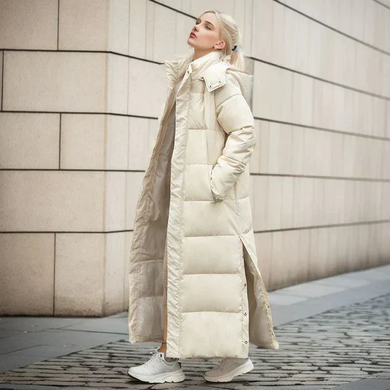 Frau in langem beigem Daunenmantel, Wintermode, stilvoll, warm, urbaner Hintergrund.