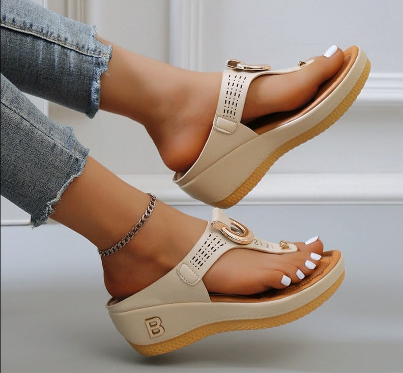 Beige Damen-Sandalen mit Keilabsatz, perforiertem Design und goldenen Details, ideal für Sommer.