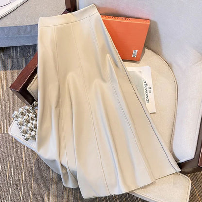 Beiger Lederrock, A-Linie, auf Sessel, elegantes Design, Damenmode, stilvoll, modern.