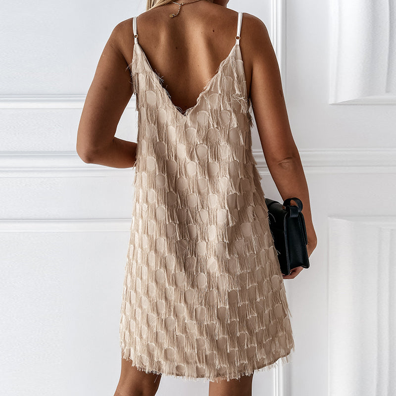 Frau im ärmellosen, beige Fransen-Kleid, Rückansicht, elegantes Sommeroutfit.
